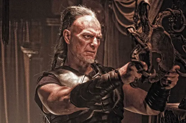 Khalar Zym (Stephen Lang) sujetando la máscara de Acheron