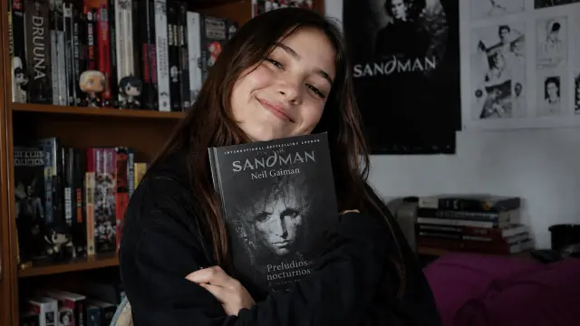Una fan de Sandman posa con su ejemplar